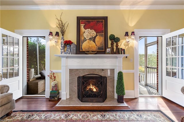 sitting room featuring crown molding, wood finished floors, and a wealth of natural light