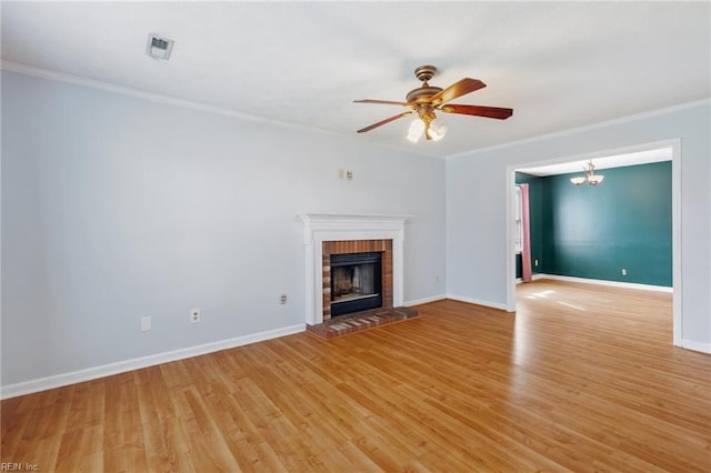 unfurnished living room with ornamental molding, light wood-style flooring, and a brick fireplace