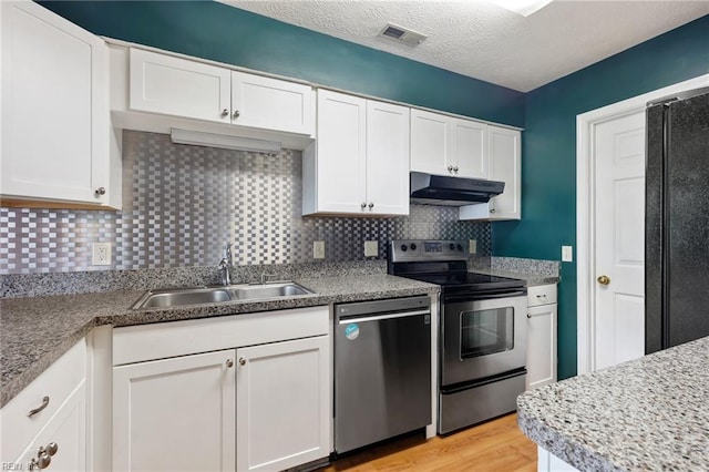 kitchen featuring a sink, visible vents, under cabinet range hood, white cabinets, and appliances with stainless steel finishes