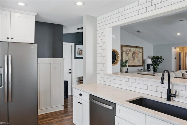kitchen featuring decorative backsplash, dark wood-style flooring, a sink, white cabinets, and stainless steel appliances