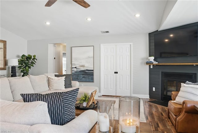 living area featuring visible vents, a fireplace with flush hearth, wood finished floors, recessed lighting, and a ceiling fan