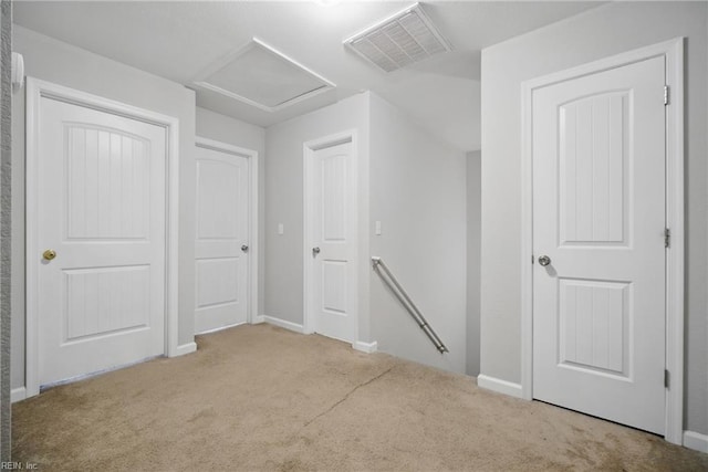 unfurnished bedroom with carpet floors, baseboards, visible vents, and attic access