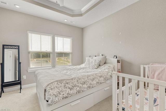 bedroom featuring visible vents, recessed lighting, a raised ceiling, and light carpet