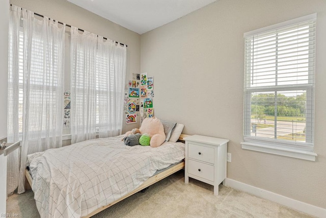 bedroom with baseboards and light carpet