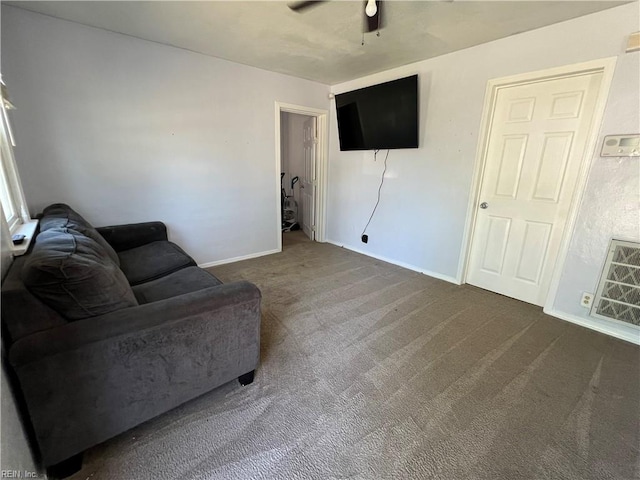 living room featuring dark colored carpet, a ceiling fan, baseboards, and visible vents