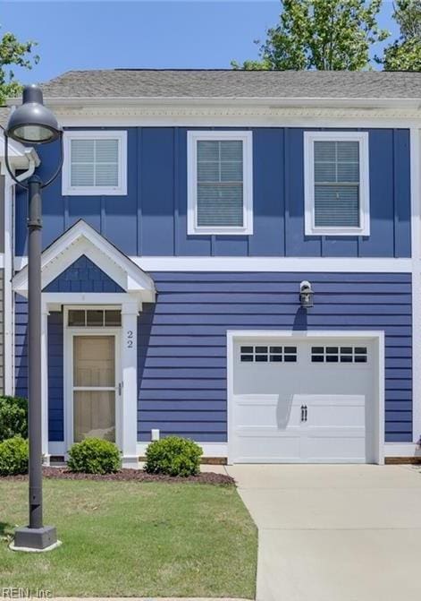 view of front of home featuring an attached garage, a front lawn, and driveway