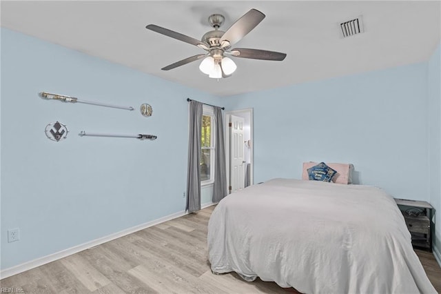 bedroom with visible vents, baseboards, ceiling fan, and wood finished floors