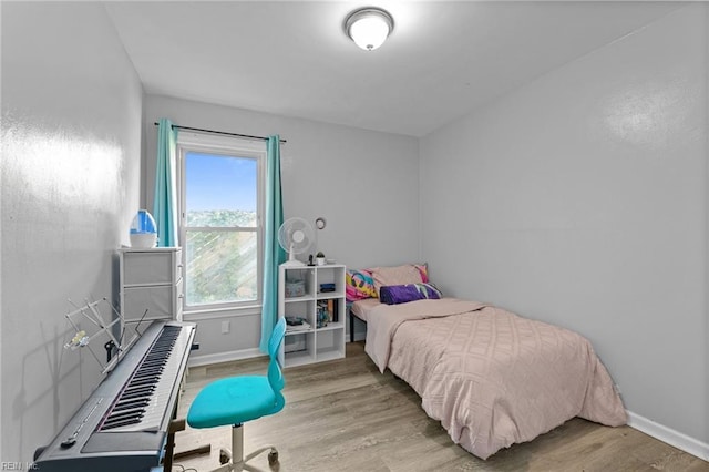 bedroom with baseboards and wood finished floors