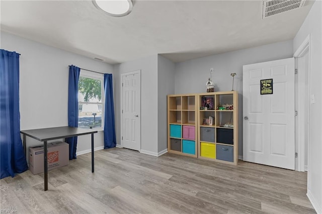 interior space featuring baseboards, wood finished floors, and visible vents