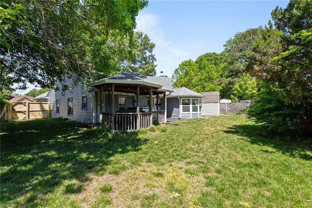back of property featuring fence and a yard