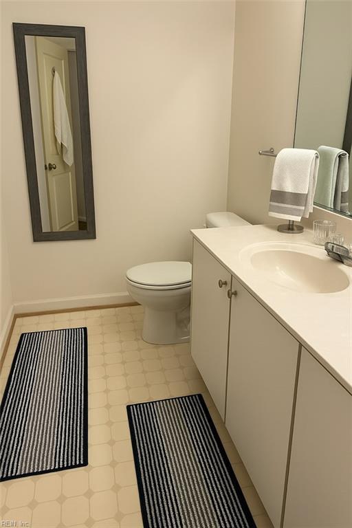 bathroom featuring vanity, baseboards, and toilet