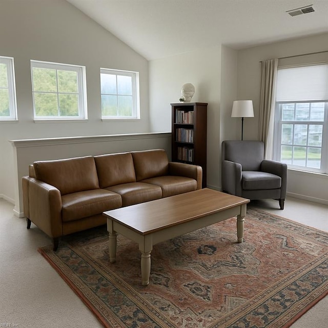 living area featuring visible vents, baseboards, carpet floors, and lofted ceiling