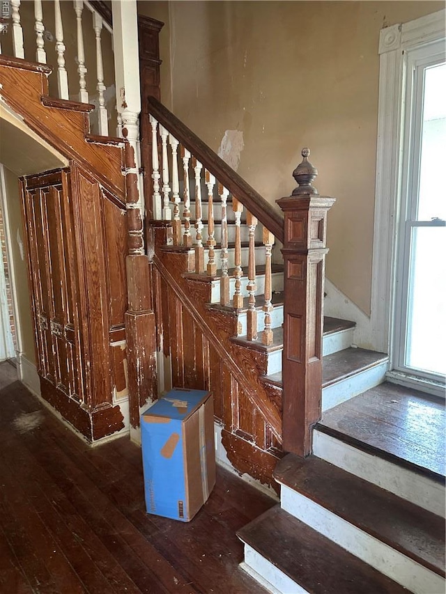 stairway featuring wood-type flooring and a wealth of natural light