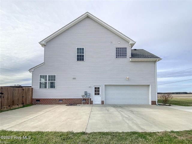 view of side of home with an attached garage, fence, and crawl space