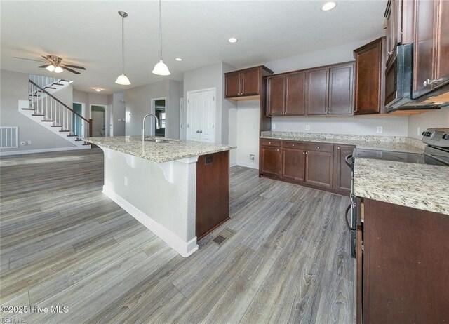 kitchen featuring recessed lighting, a sink, light wood-style flooring, and black microwave