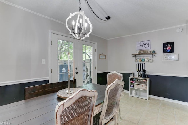 dining space with an inviting chandelier, ornamental molding, tile patterned flooring, a textured ceiling, and french doors
