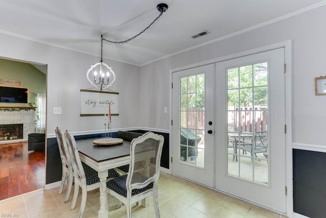 tiled dining room featuring an inviting chandelier, ornamental molding, french doors, and visible vents