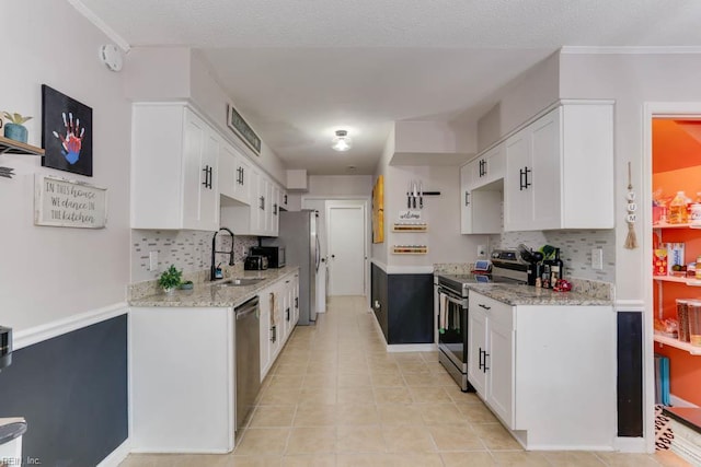 kitchen with a sink, tasteful backsplash, stainless steel appliances, and white cabinets