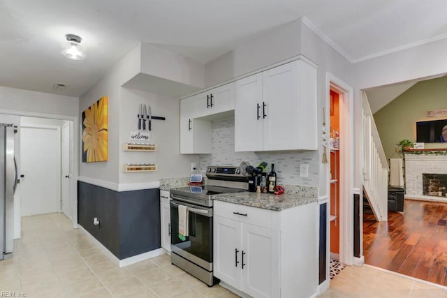 kitchen featuring white cabinetry, appliances with stainless steel finishes, decorative backsplash, and light tile patterned floors