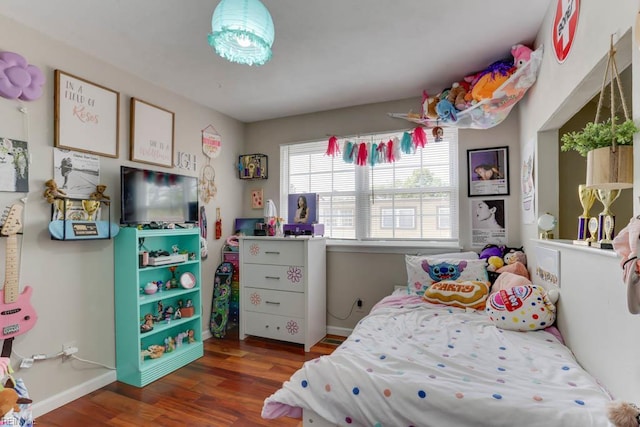 bedroom featuring baseboards and wood finished floors