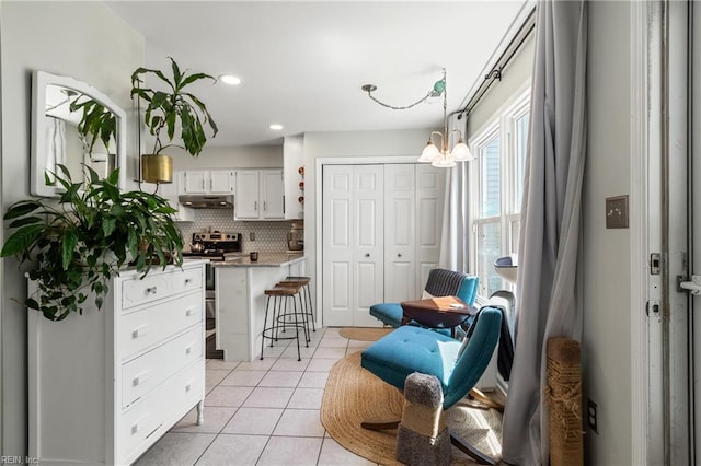 living area featuring recessed lighting, light tile patterned floors, and a notable chandelier