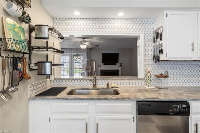 kitchen with stainless steel dishwasher, ceiling fan, white cabinets, tasteful backsplash, and a sink
