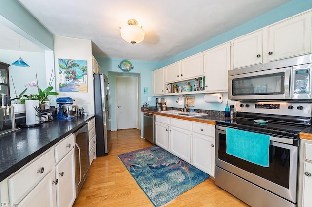 12 Rudee Ave, Virginia Beach, VA 23451 - kitchen featuring white cabinets, stainless steel appliances, a sink, and light wood finished floors