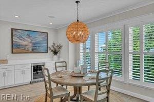 dining area featuring crown molding, baseboards, plenty of natural light, and wine cooler