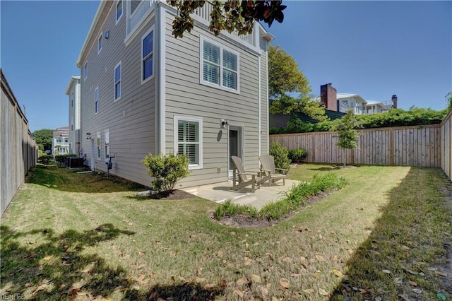rear view of property featuring a fenced backyard, a yard, a patio, and cooling unit