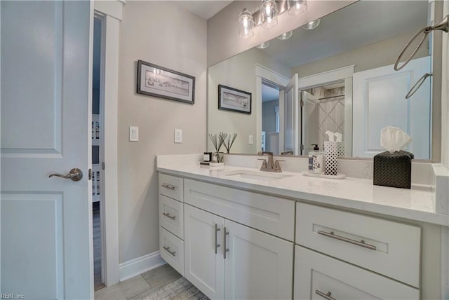 bathroom featuring vanity, baseboards, and tile patterned flooring