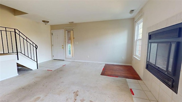 carpeted foyer entrance with stairway and baseboards