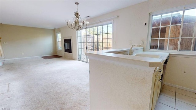 kitchen featuring a chandelier, baseboards, a sink, and hanging light fixtures