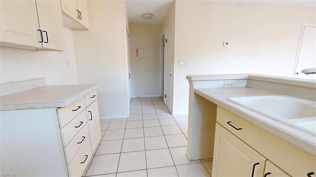 kitchen with light countertops, light tile patterned flooring, and baseboards
