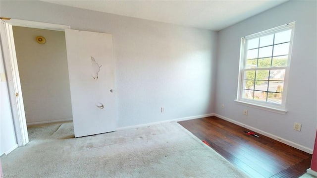 unfurnished room with baseboards and wood finished floors