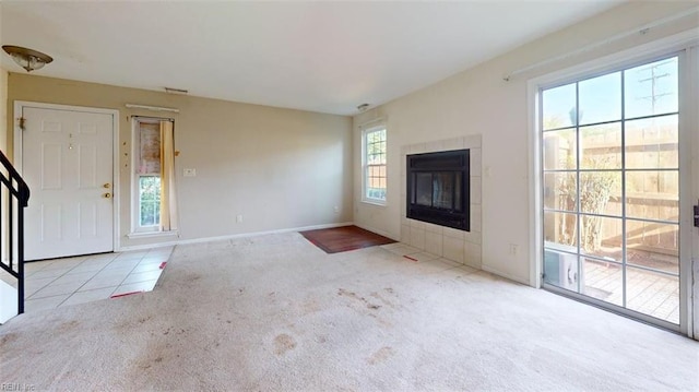 unfurnished living room featuring carpet flooring, a fireplace, and baseboards