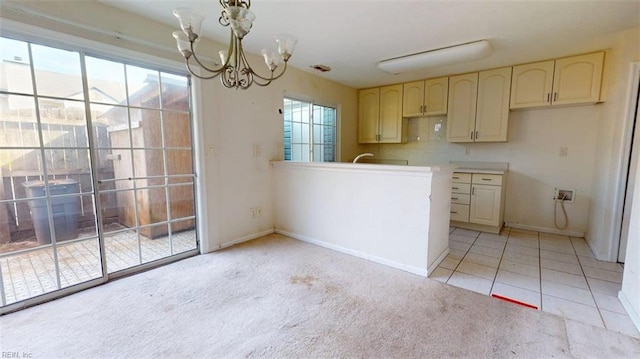 kitchen featuring a chandelier, light colored carpet, baseboards, and light tile patterned floors