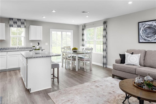 living area featuring visible vents, recessed lighting, baseboards, and light wood-type flooring
