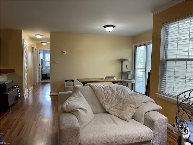 living area with baseboards and wood finished floors