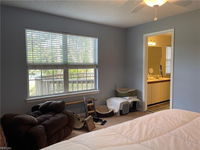 bedroom featuring carpet floors, a ceiling fan, a textured ceiling, and ensuite bathroom