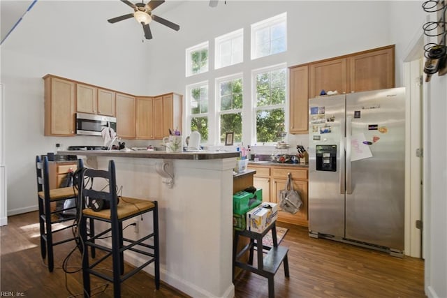 422 New London Pl, Virginia Beach, VA 23454 - kitchen featuring a towering ceiling, a breakfast bar, dark wood-style floors, a ceiling fan, and appliances with stainless steel finishes
