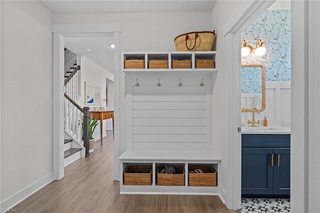 mudroom with a sink and wood finished floors