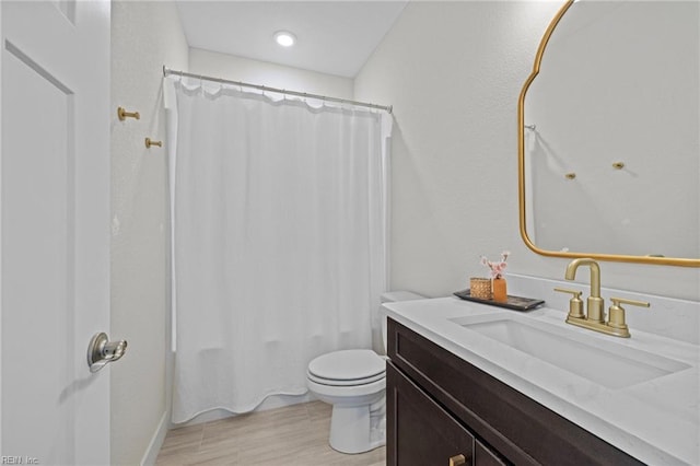 full bath featuring toilet, wood finished floors, shower / tub combo, and vanity