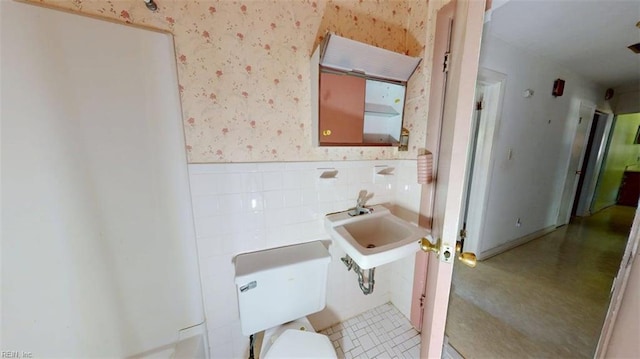 3702 Nansemond Pkwy, Suffolk, VA 23435 - half bath with wallpapered walls, a wainscoted wall, a sink, and toilet