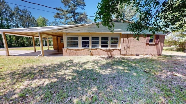 3702 Nansemond Pkwy, Suffolk, VA 23435 - back of house with a carport, brick siding, and a yard