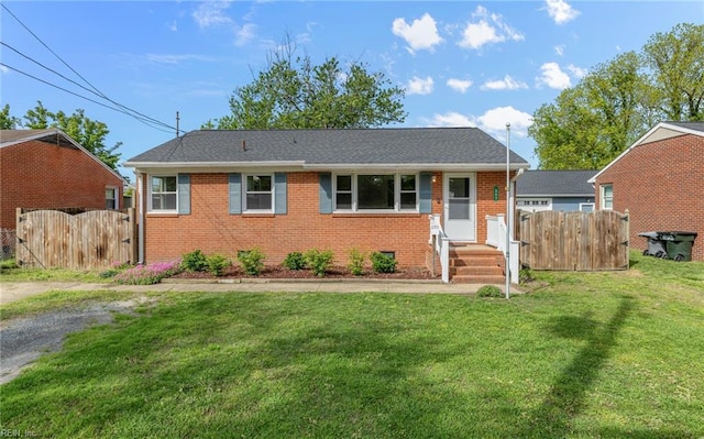 view of front facade featuring fence, a gate, brick siding, and a front yard