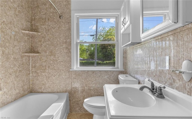 bathroom featuring plenty of natural light, vanity, toilet, and tile walls