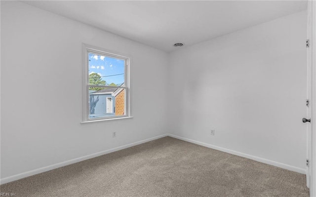 unfurnished room with carpet floors, baseboards, and visible vents
