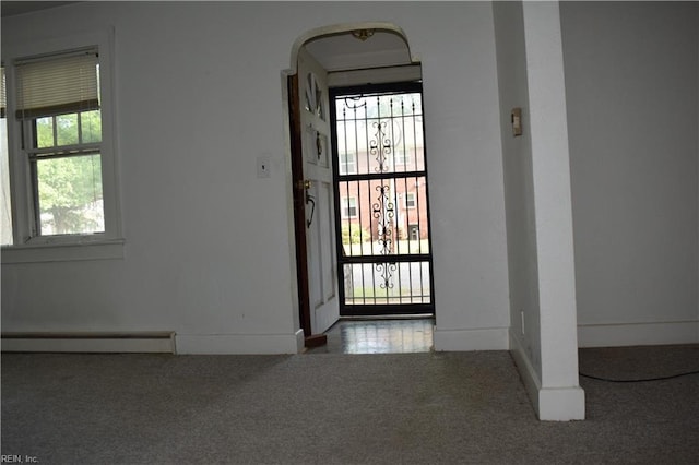 foyer entrance with baseboards, a baseboard radiator, and carpet