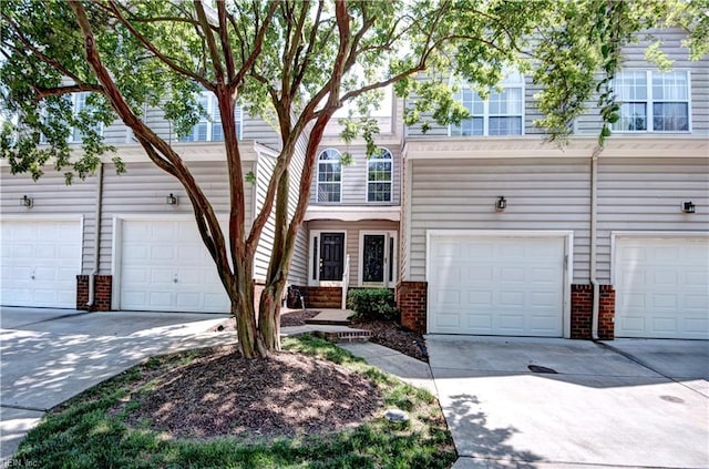 view of front facade with an attached garage, driveway, and brick siding