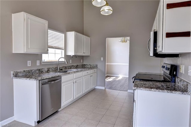 kitchen featuring a sink, baseboards, white cabinets, a high ceiling, and stainless steel appliances